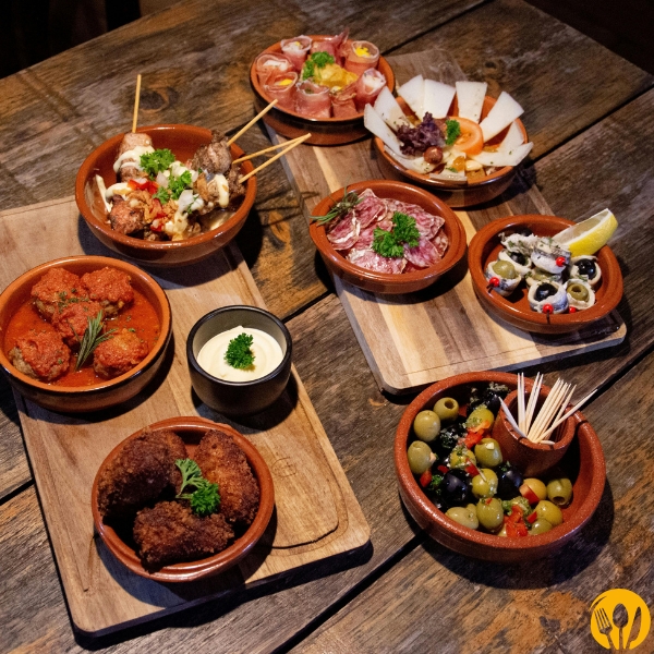 Zestaw przystawek w małych miseczkach na drewnianych deskach, ujęcie z góry.