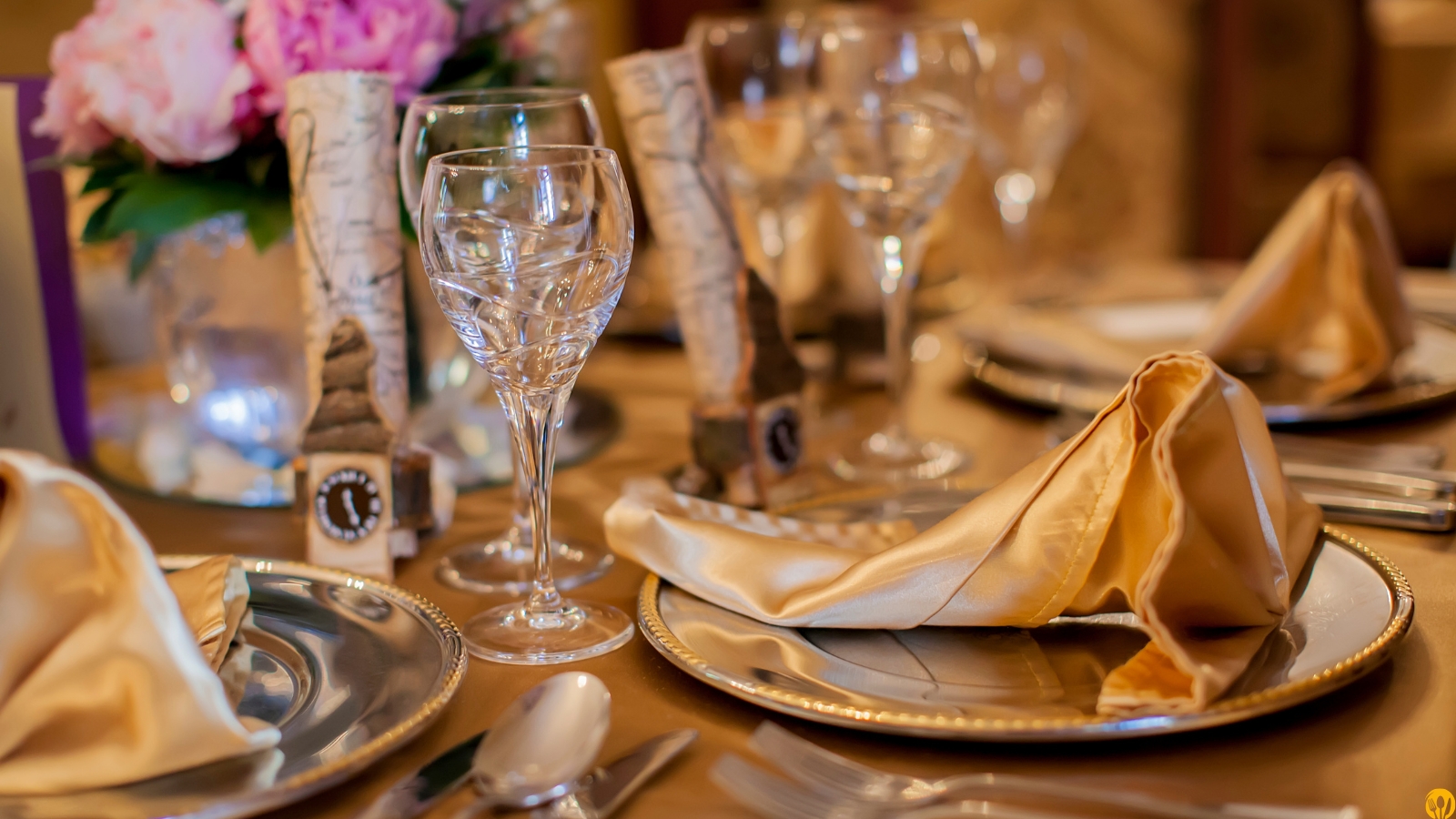 Wnętrze eleganckiej restauracji z okrągłymi stolikami i złotym oświetleniem – demo strony gastronomicznej